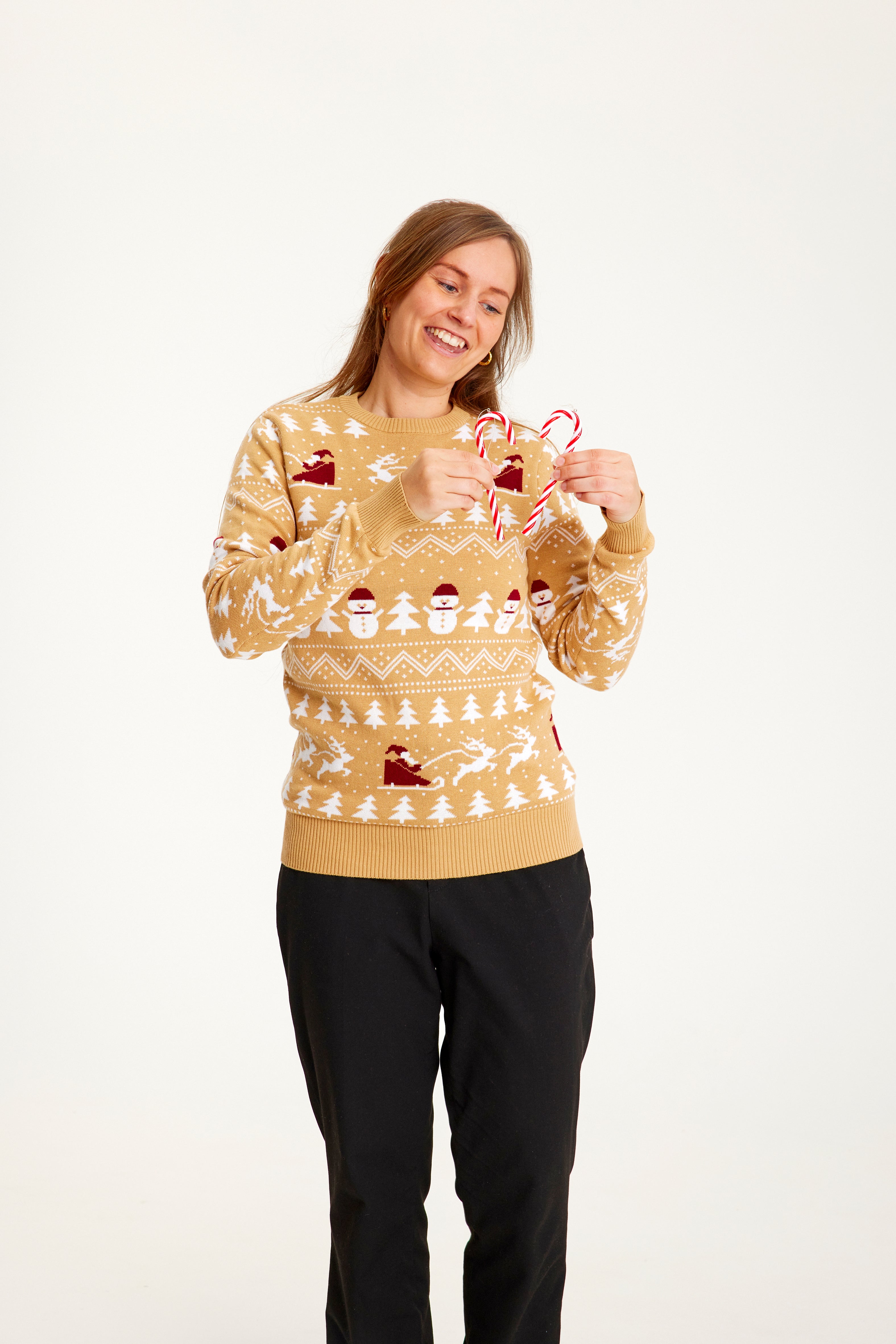 Ein Mann trägt einen beigen Weihnachtspulli mit einem Muster darauf.